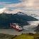 A helicopter flying in the sky near snow dusted mountains